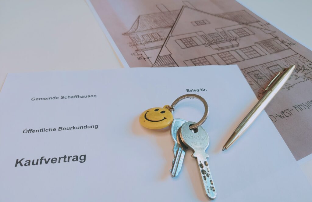 Dokumente liegen auf dem Tisch, Kauvertrag, Schlüssel und ein Stift