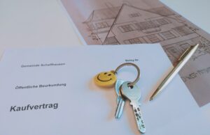 Dokumente liegen auf dem Tisch, Kauvertrag, Schlüssel und ein Stift