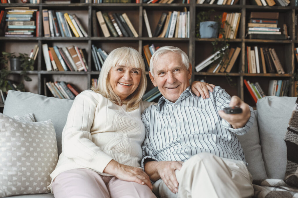 Zwei ältere Personen schauen zusammen Fernsehen
